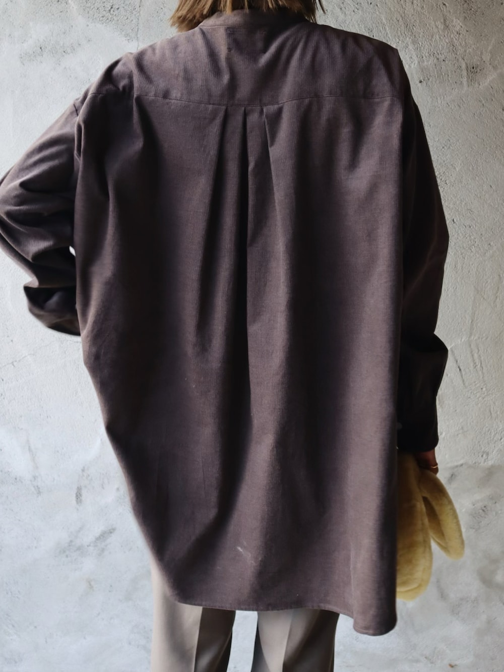 グレー系のシャツ/ブラウス、イエロー系のハンドバッグ、ホワイト系のスニーカーを着用したレディースの秋コーディネートの3枚目の写真