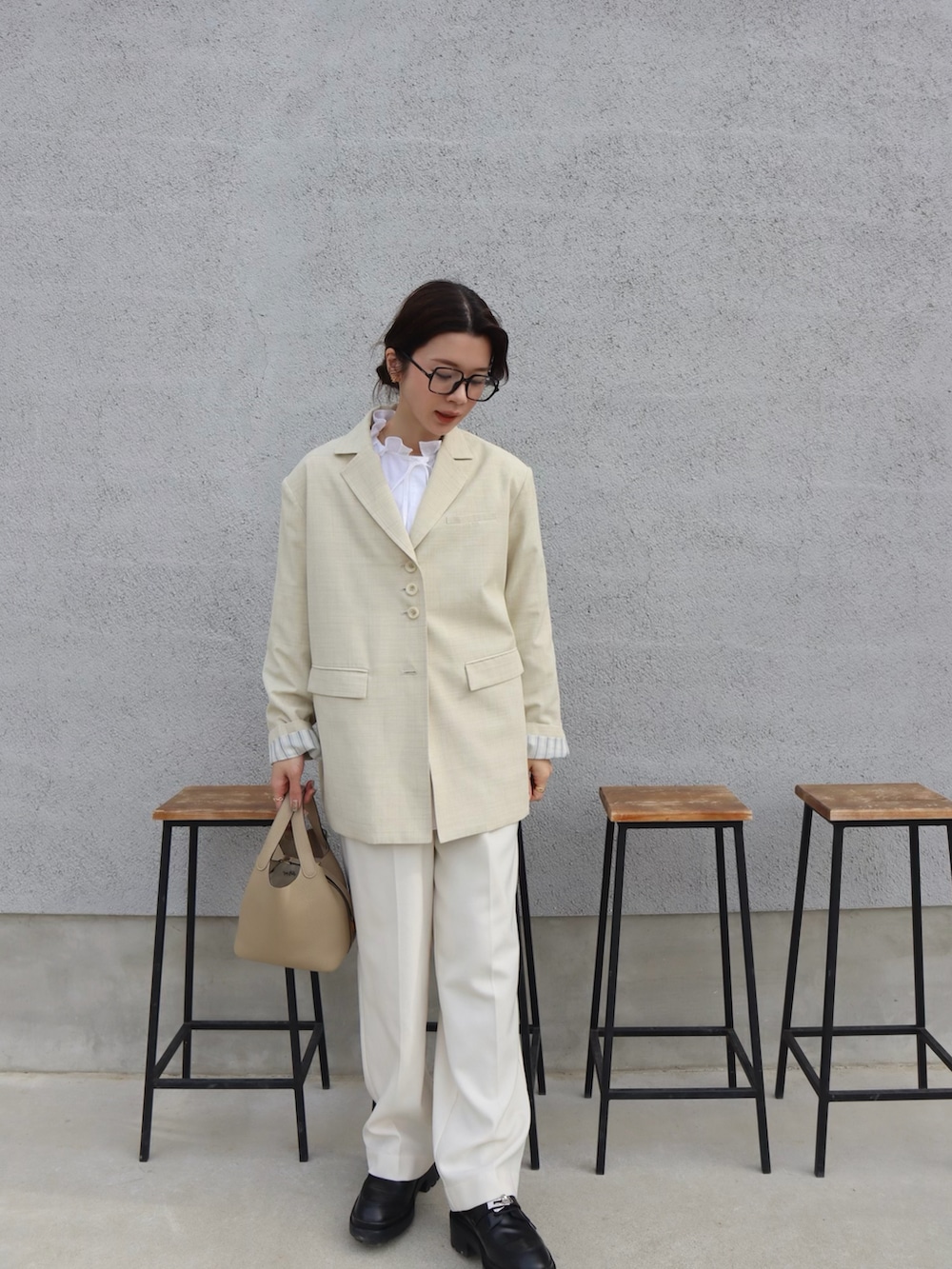 ホワイト系のシャツ/ブラウス、イエロー系のテーラードジャケット、ホワイト系のスラックスを着用したレディースの春コーディネートの3枚目の写真