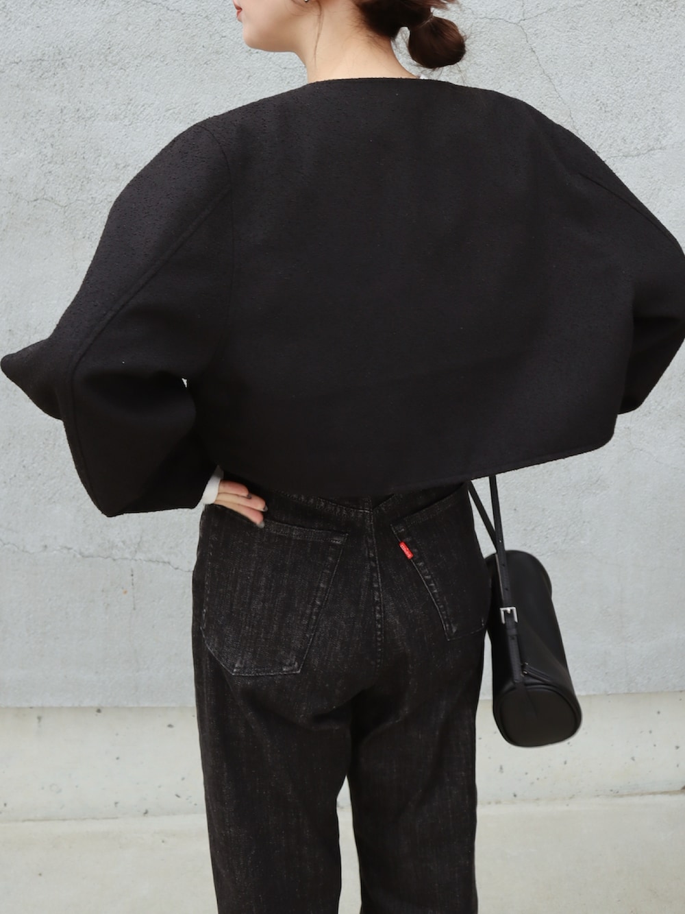 ブラック系のデニムパンツ、ブラック系のノーカラージャケット、ホワイト系のTシャツ/カットソーを着用したレディースの春コーディネートの3枚目の写真