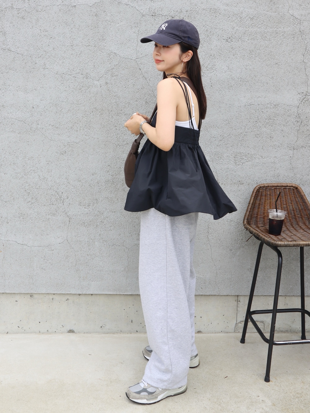 ブラック系のキャミソール、グレー系のスウェットパンツ、ブラウン系のショルダーバッグを着用したレディースの春コーディネートの2枚目の写真