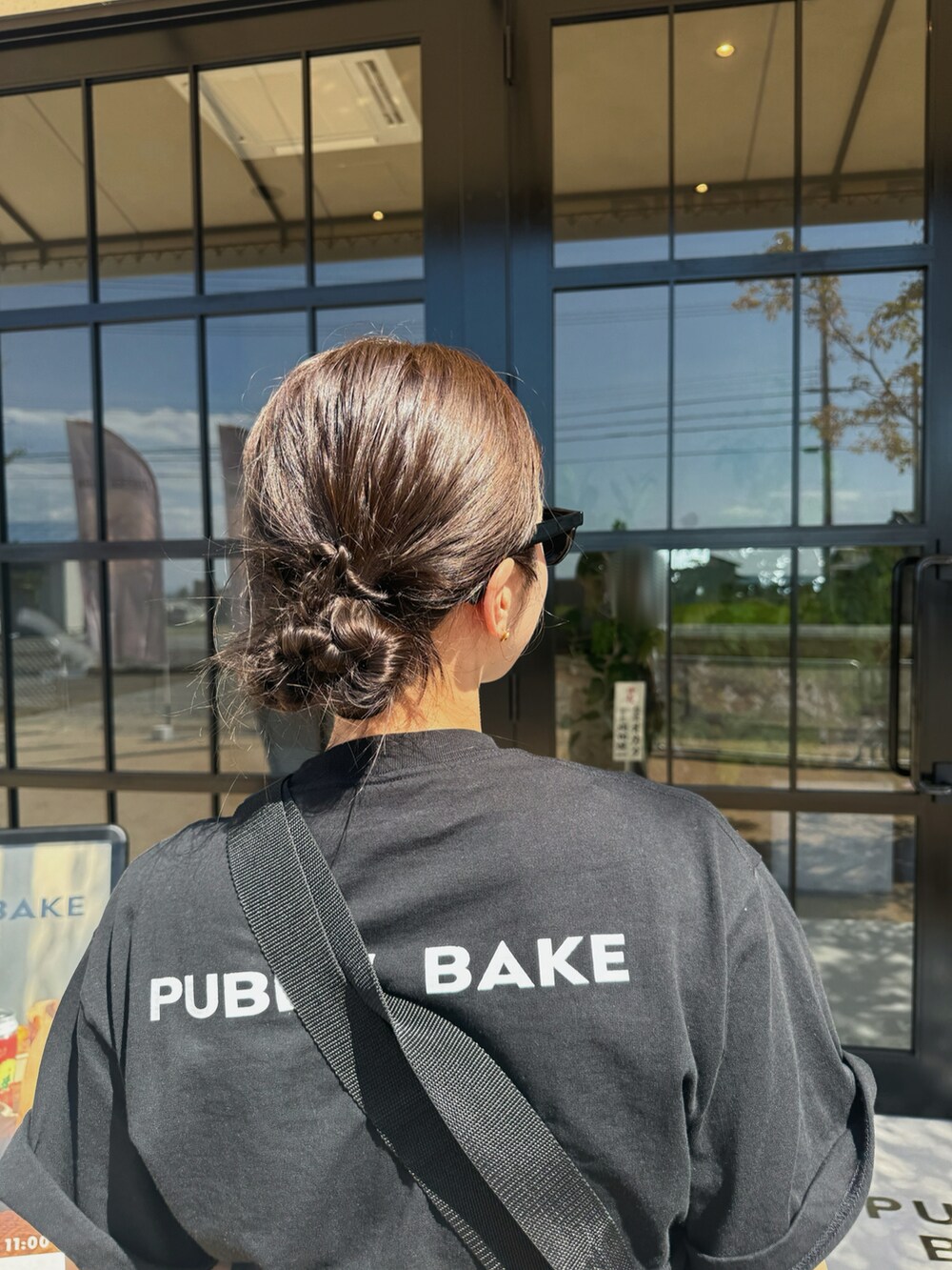 ブラック系のTシャツ/カットソー、ベージュ系のチノパンツ、ブラック系のスニーカーを着用したレディースの夏コーディネートの2枚目の写真