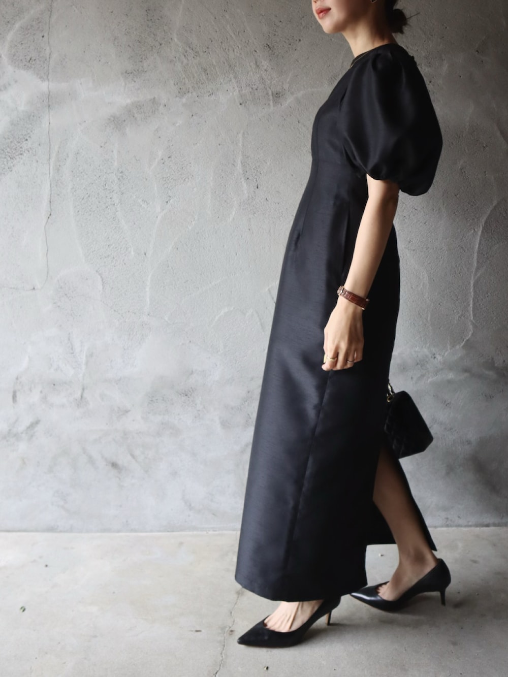 ブラック系のパンプス、ブラック系のドレス、ピンク系のアイシャドウを着用したレディースの春コーディネートの2枚目の写真