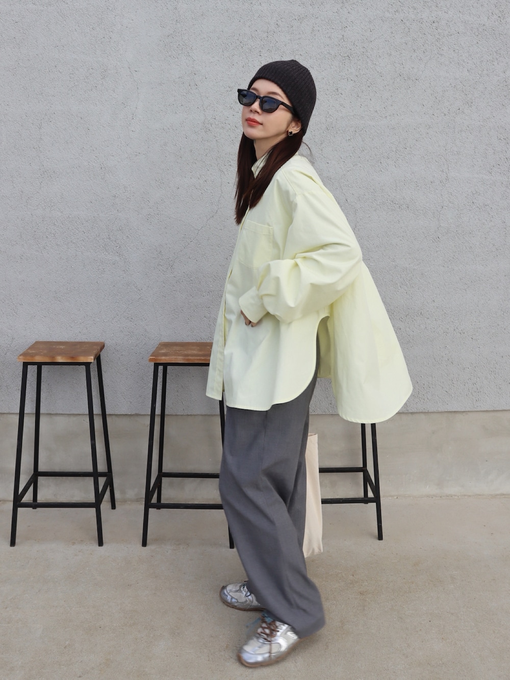 イエロー系のシャツ/ブラウス、ブラック系のベスト、グレー系のスラックスを着用したレディースの冬コーディネートの2枚目の写真