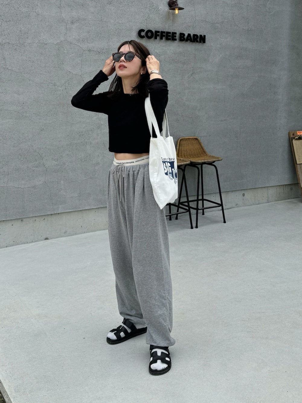 ブラック系のTシャツ/カットソー、グレー系のスウェットパンツ、ブラック系のサンダルを着用したレディースの夏コーディネートの2枚目の写真