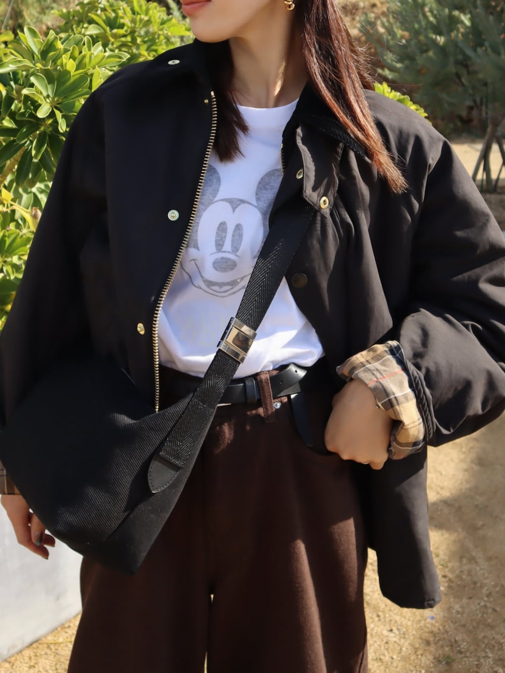 ブラック系のその他アウター、ホワイト系のTシャツ/カットソー、ブラウン系のパンツを着用したレディースの冬コーディネートの2枚目の写真