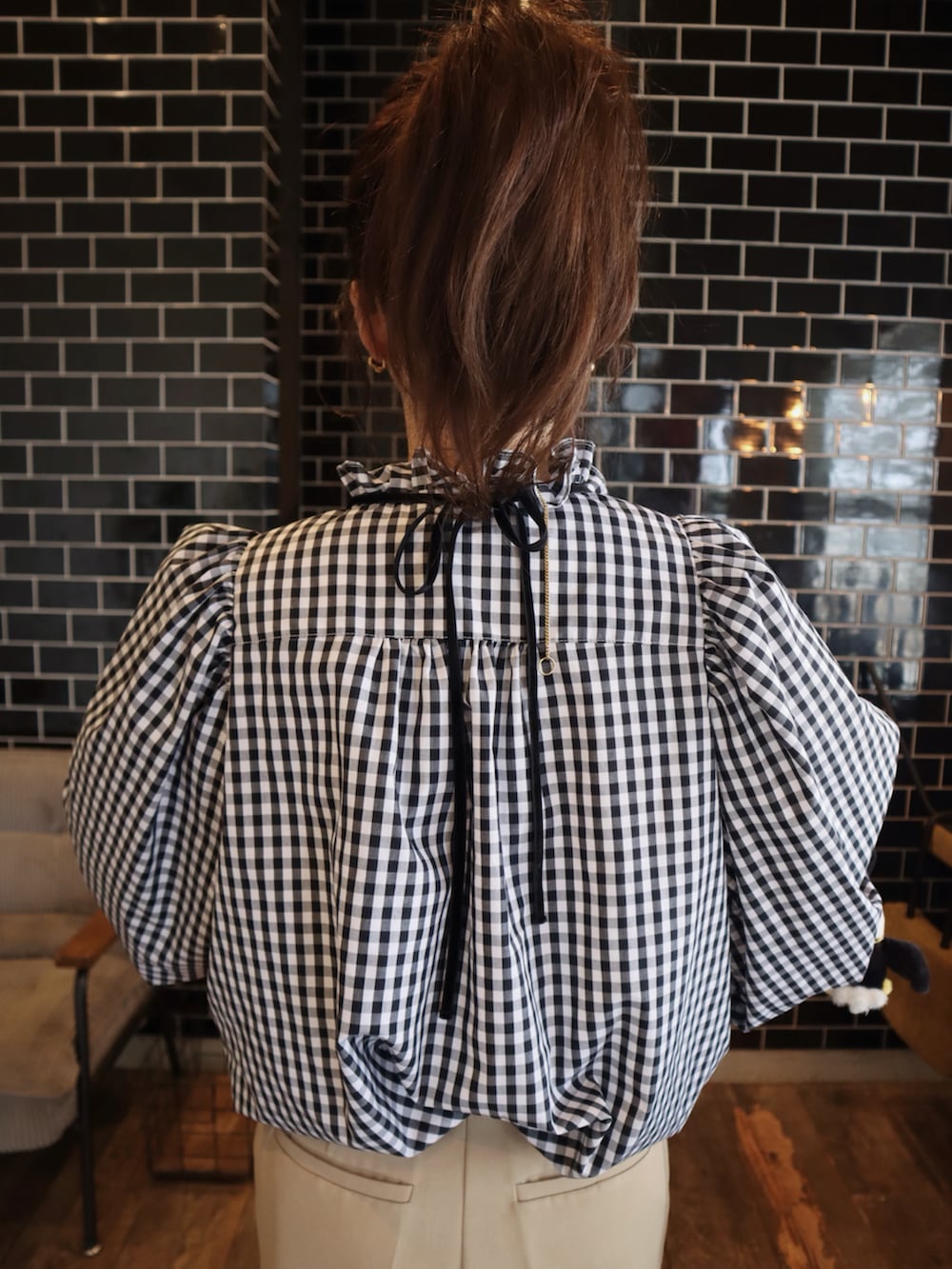 ブラック系のシャツ/ブラウス、ベージュ系のスラックスを着用したレディースの春コーディネートの3枚目の写真