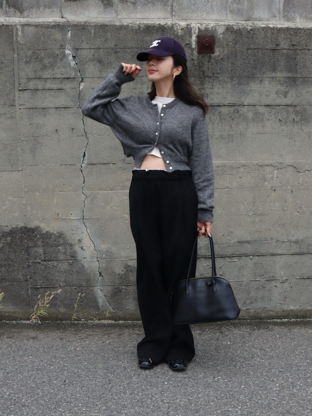 グレー系のカーディガン/ボレロ、ブラック系のスラックス、ブラック系のハンドバッグを着用したレディースの秋コーディネートの2枚目の写真