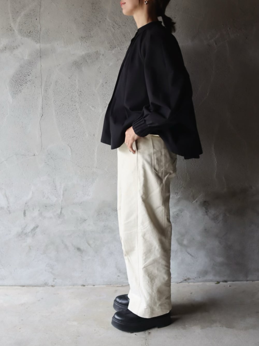 ブラック系のシャツ/ブラウス、ホワイト系のその他パンツ、ブラック系のブーツを着用したレディースの冬コーディネートの2枚目の写真