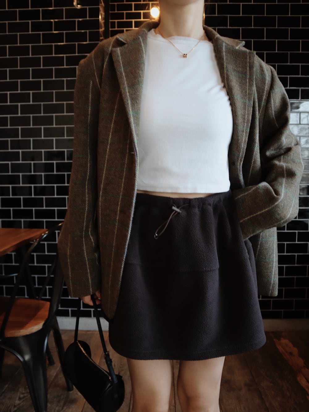 ホワイト系のTシャツ/カットソー、ブラウン系のスカート、ブラウン系のローファーを着用したレディースの秋コーディネートの2枚目の写真