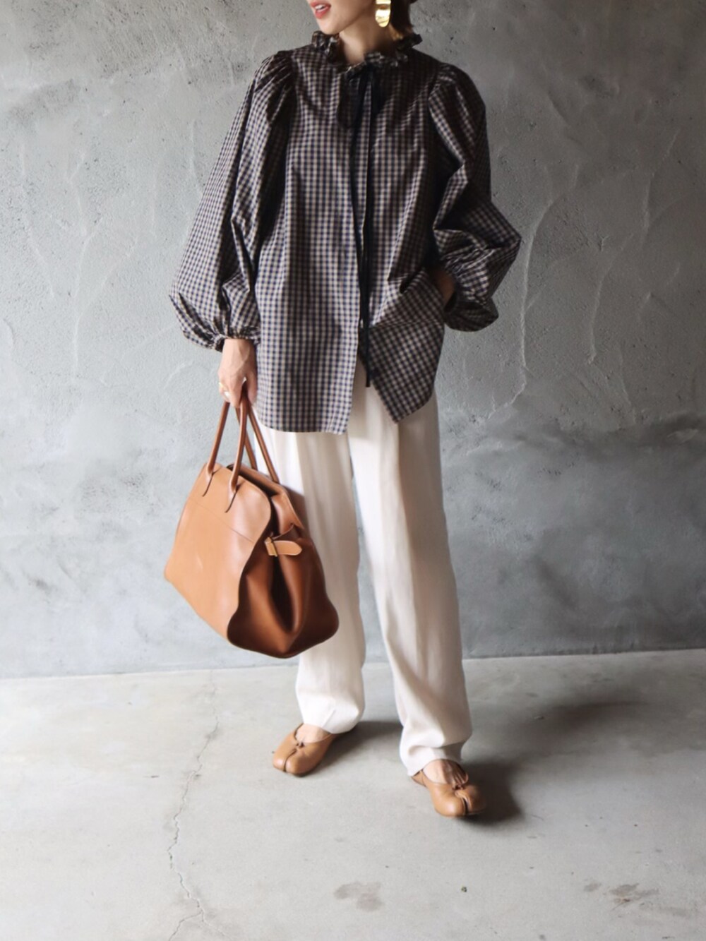 ブラウン系のシャツ/ブラウス、ホワイト系のスラックス、ブラウン系のハンドバッグを着用したレディースの秋コーディネートの2枚目の写真