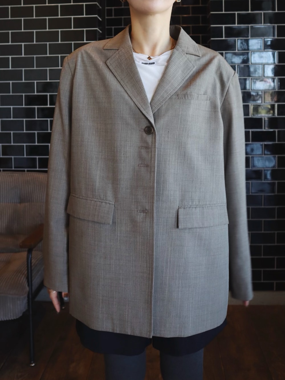 ブラウン系のテーラードジャケット、ブラック系のスニーカー、グレー系のタイツ/ストッキングを着用したレディースの冬コーディネートの2枚目の写真