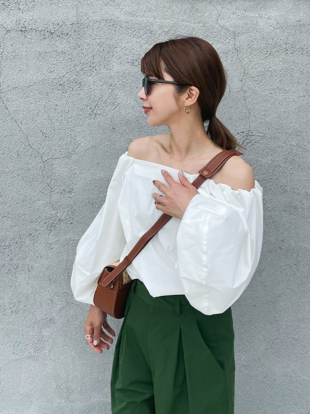 ホワイト系のシャツ/ブラウス、グリーン系のスラックス、ブラウン系のサンダルを着用したレディースの夏コーディネートの2枚目の写真