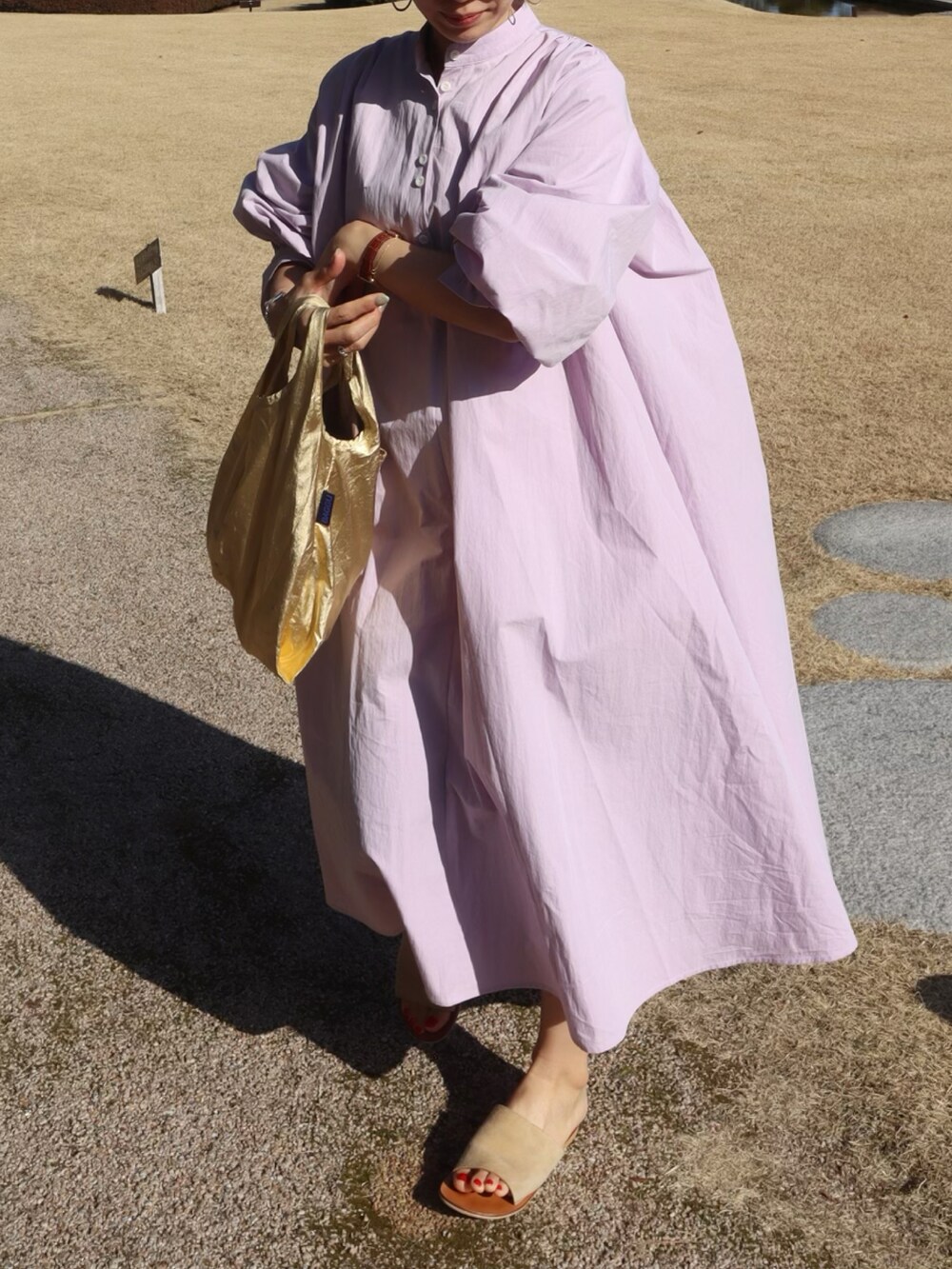 パープル系のシャツワンピース、ゴールド系のエコバッグ/サブバッグ、ベージュ系のサンダルを着用したレディースの冬コーディネートの2枚目の写真