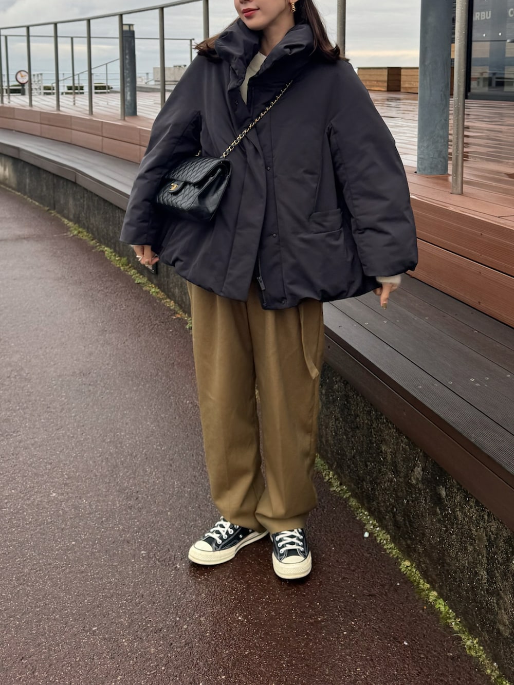 ブラック系のダウンジャケット/コート、ベージュ系のその他パンツ、グレー系のニットキャップ/ビーニーを着用したレディースの冬コーディネートの2枚目の写真