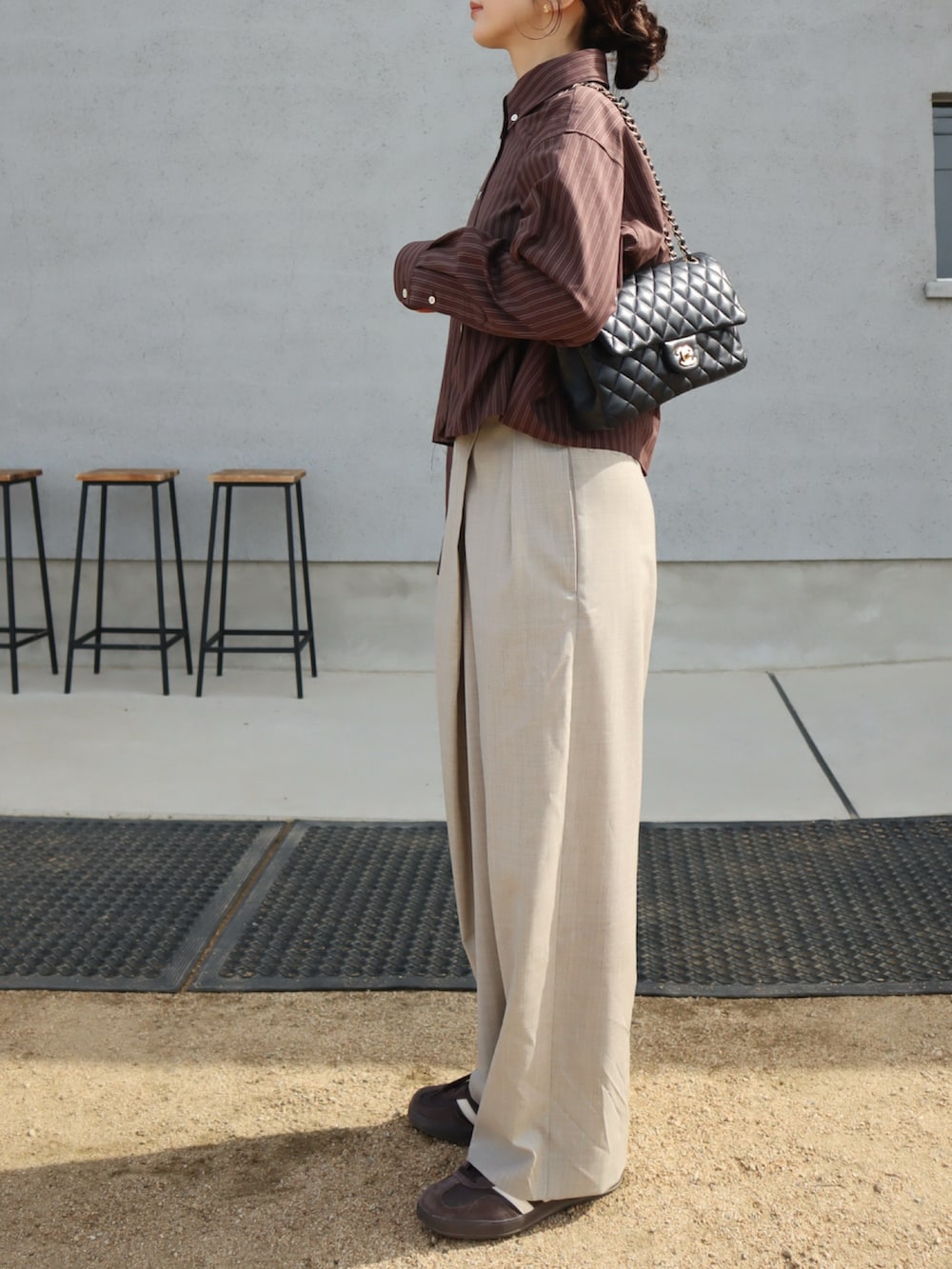 ブラウン系のスニーカー、ブラウン系のシャツ/ブラウス、グレー系のスラックスを着用したレディースの秋コーディネートの2枚目の写真