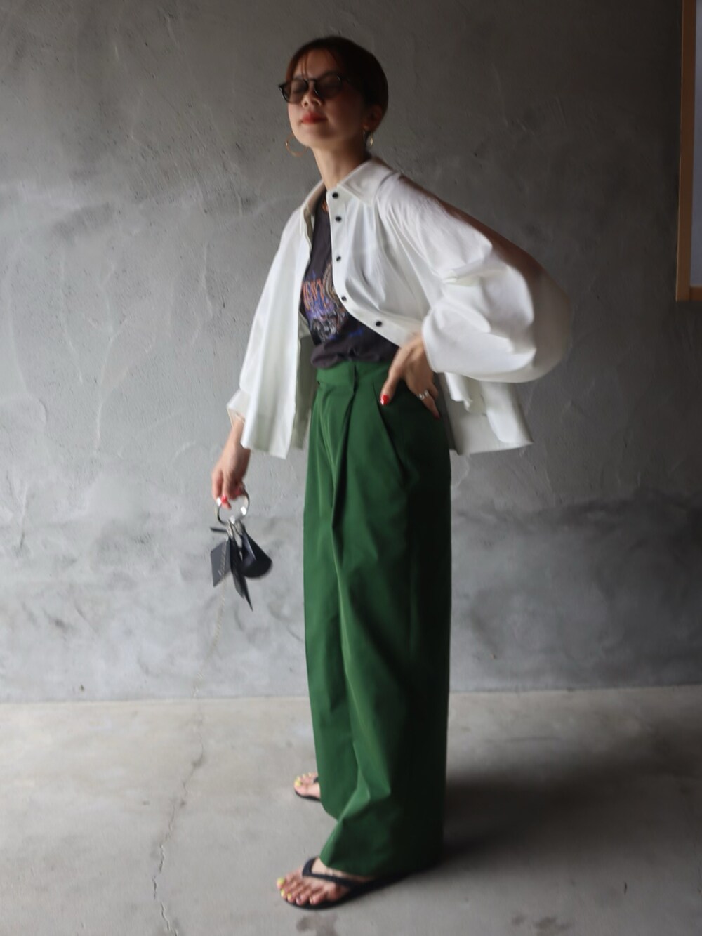ホワイト系のシャツ/ブラウス、グリーン系のスラックス、ゴールド系のピアス（両耳用）を着用したレディースの春コーディネートの2枚目の写真
