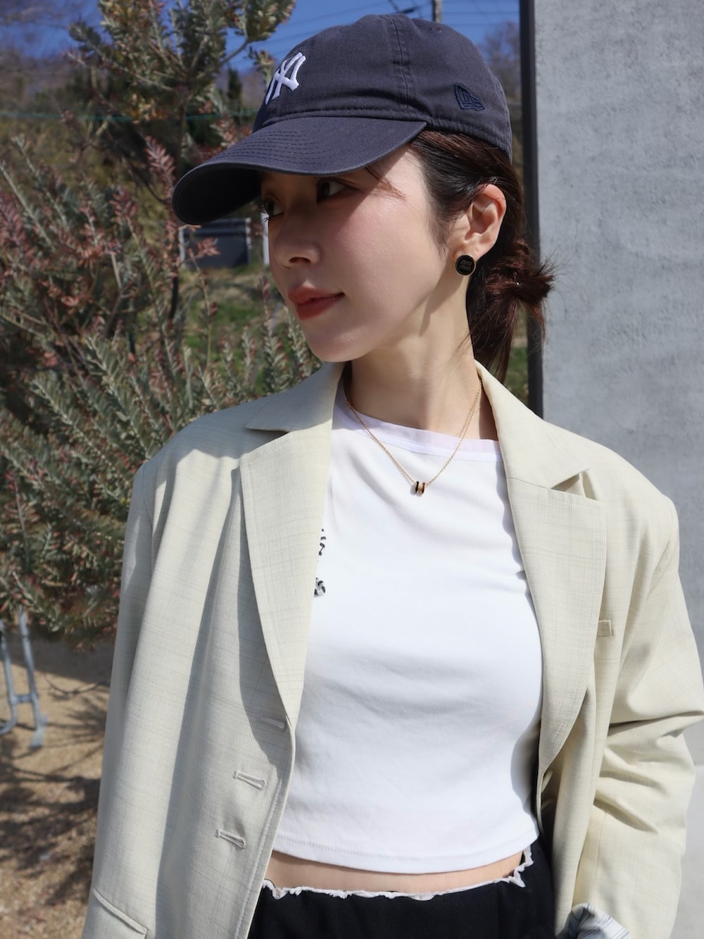 ブラウン系のスニーカー、ホワイト系のTシャツ/カットソー、イエロー系のテーラードジャケットを着用したレディースの春コーディネートの2枚目の写真