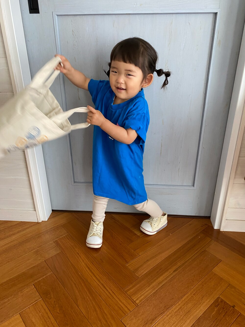 ブルー系のTシャツ/カットソー、ベージュ系のトートバッグを着用したキッズの夏コーディネートの2枚目の写真