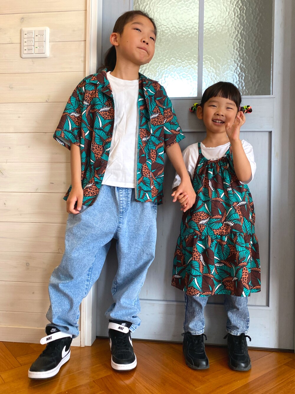 グリーン系のワンピース、グリーン系のシャツ/ブラウス、ホワイト系のTシャツ/カットソーを着用したキッズの春コーディネートの2枚目の写真