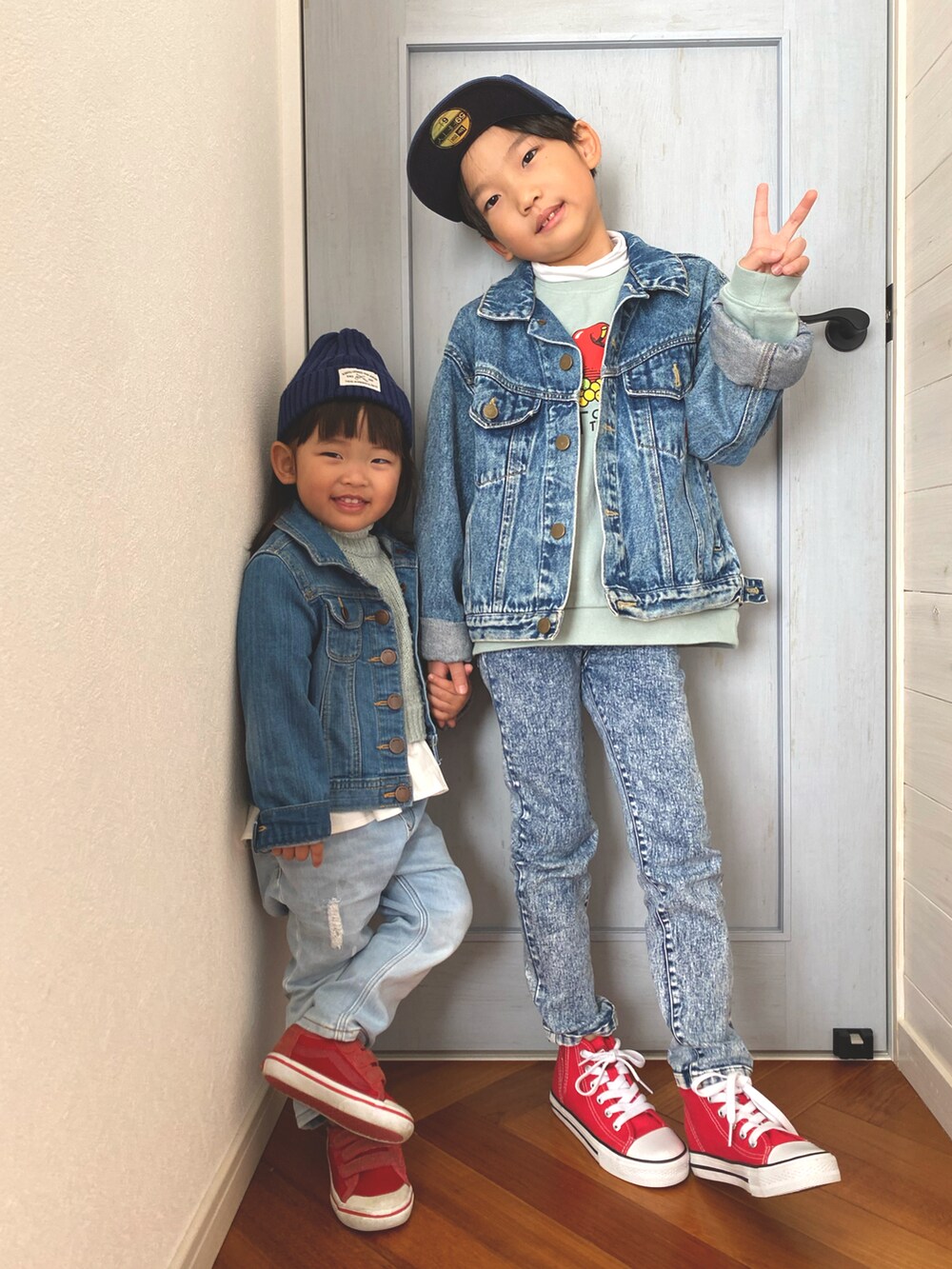 レッド系のスニーカー、グリーン系のニット/セーター、ブルー系のデニムジャケットを着用したキッズの冬コーディネートの2枚目の写真