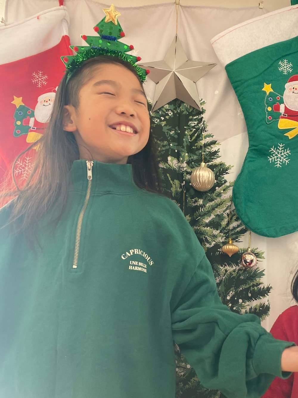 グリーン系のスウェット、レッド系のカチューシャ、グリーン系のカチューシャを着用したキッズの冬コーディネートの2枚目の写真