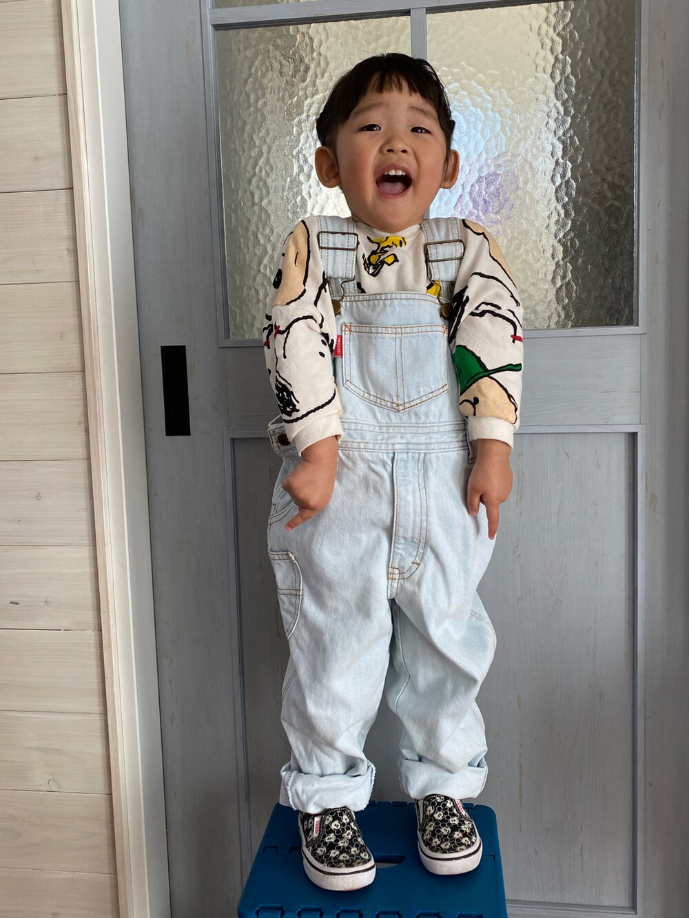 ホワイト系のセットアップ、ブルー系のサロペット/オーバーオール、ブラック系のスリッポンを着用したキッズの春コーディネートの3枚目の写真