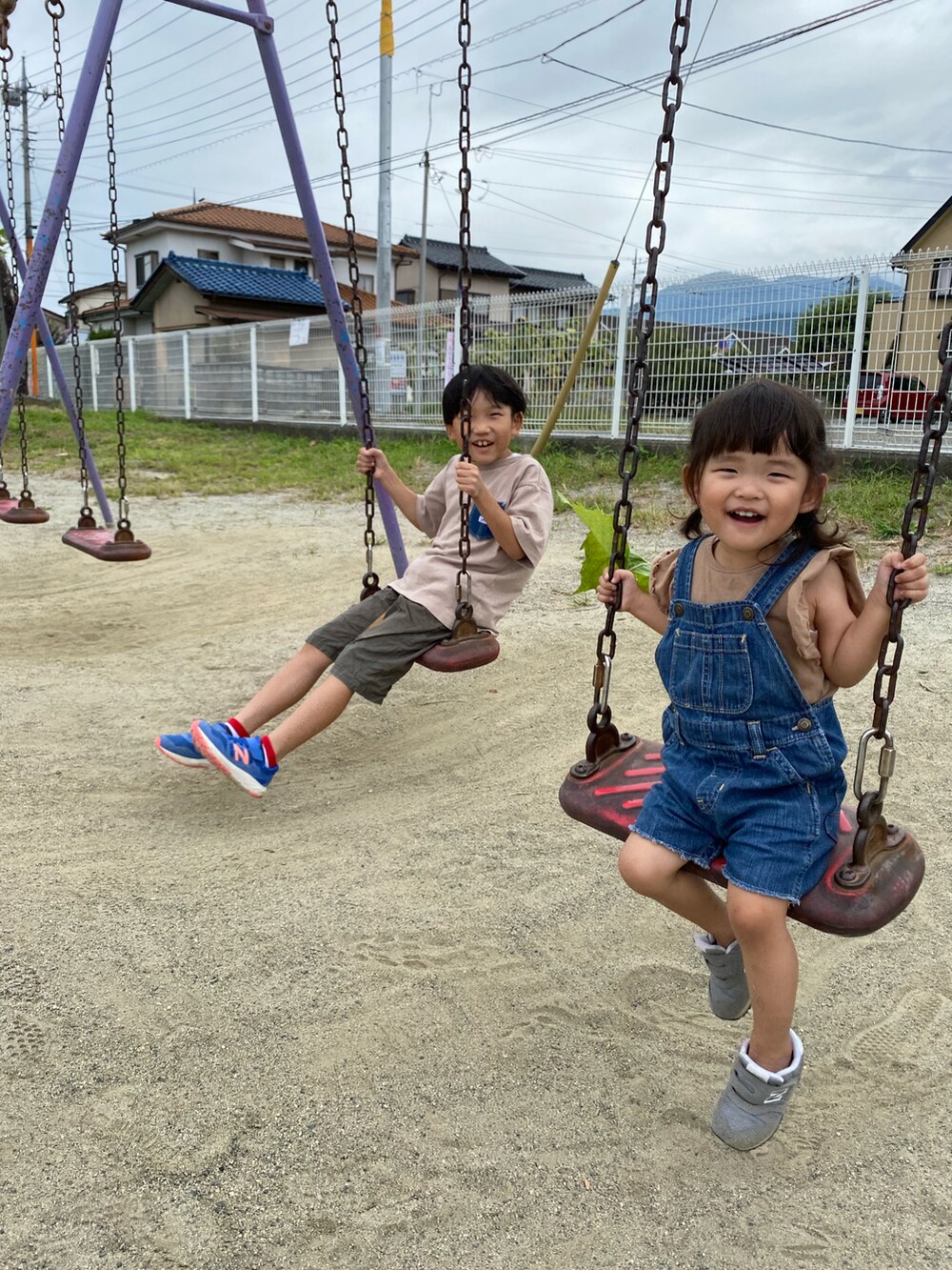 ベージュ系のTシャツ/カットソー、ブルー系のサロペット/オーバーオール、ブルー系のスニーカーを着用したキッズの秋コーディネートの3枚目の写真