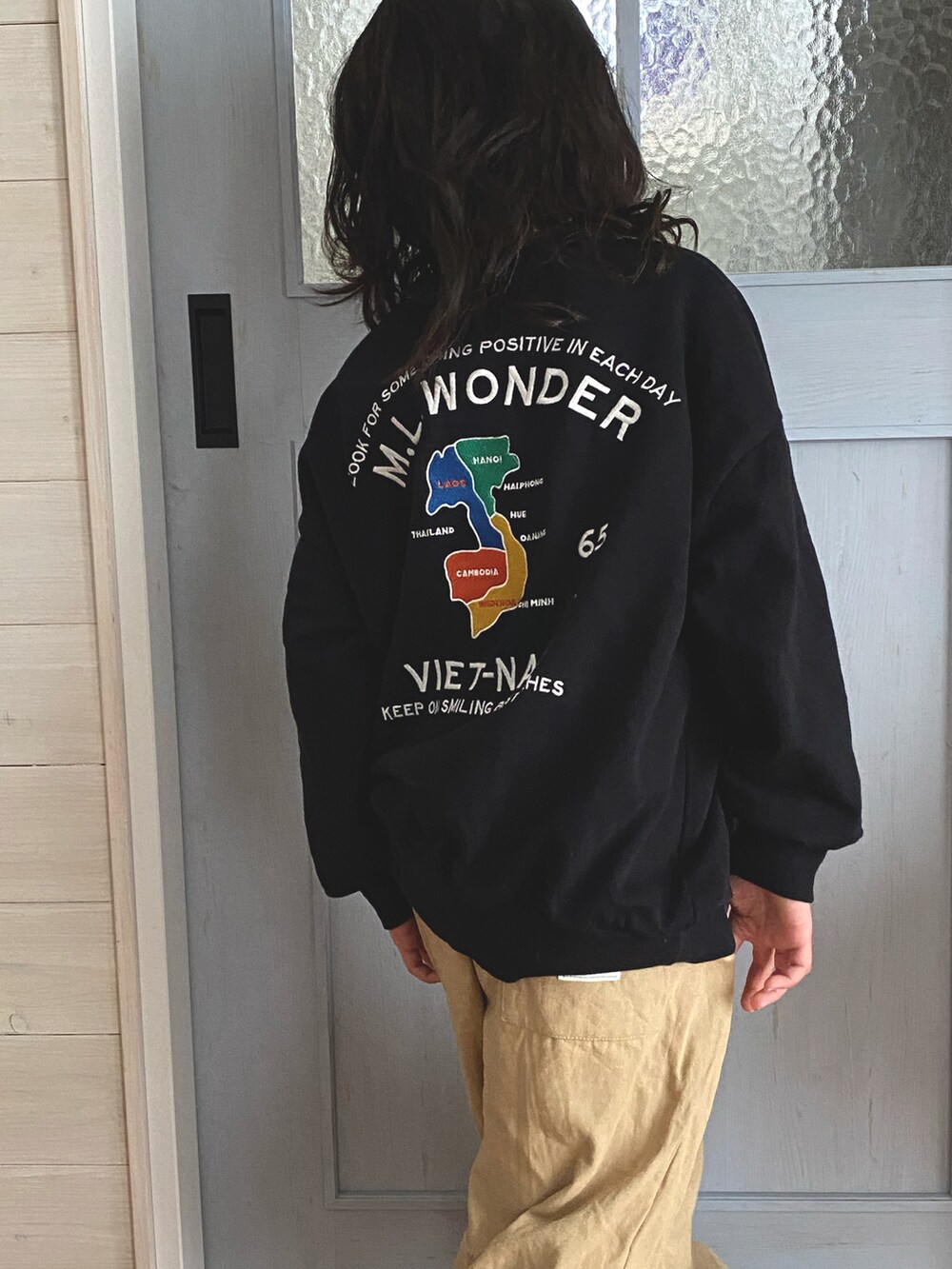 ブラック系のトップス、ベージュ系のスラックス、レッド系のスニーカーを着用したキッズの冬コーディネートの2枚目の写真
