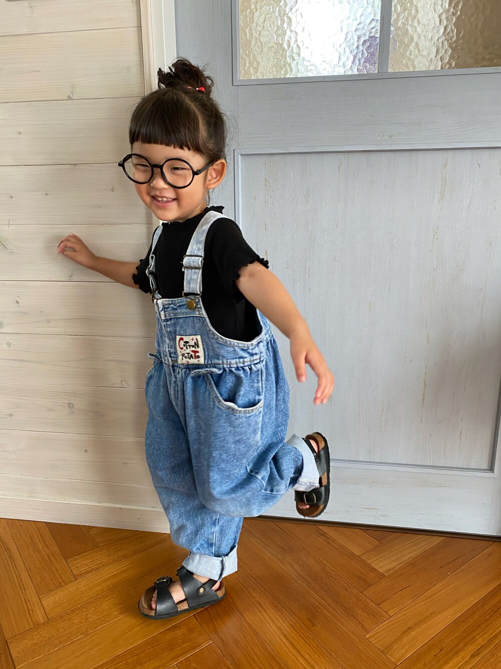 ブルー系のサロペット/オーバーオール、ブラック系のサンダル、ブラック系のTシャツ/カットソーを着用したキッズの夏コーディネートの3枚目の写真