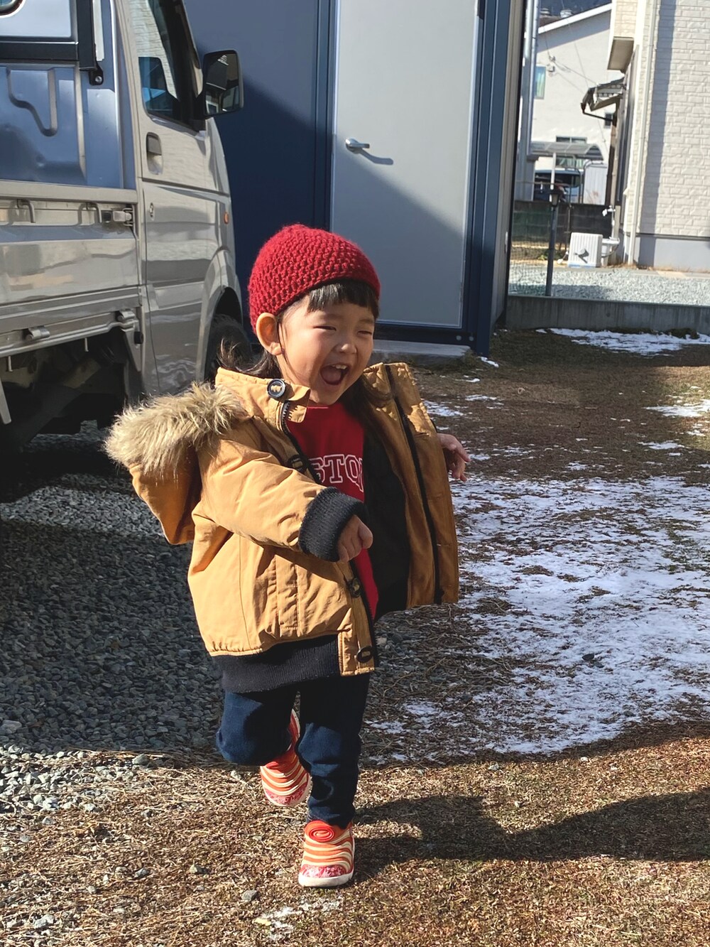 ベージュ系のその他アウター、レッド系のスニーカー、ブラック系のその他パンツを着用したキッズの冬コーディネートの3枚目の写真