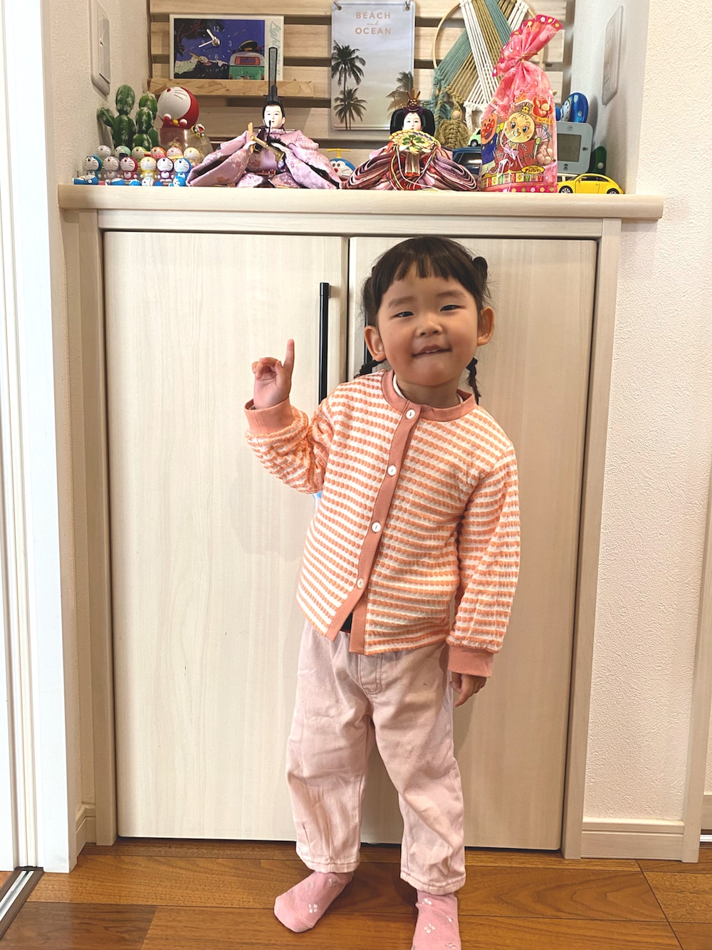 ピンク系のカーディガン/ボレロ、ピンク系のデニムパンツ、ピンク系のソックス/靴下を着用したキッズの春コーディネートの2枚目の写真