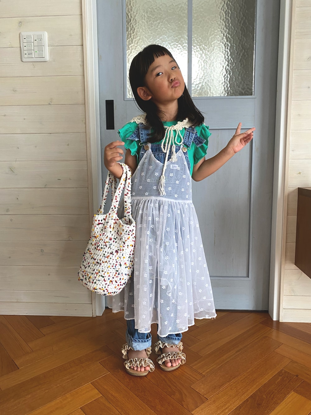 ホワイト系のワンピース、ベージュ系のサンダルを着用したキッズの夏コーディネートの2枚目の写真