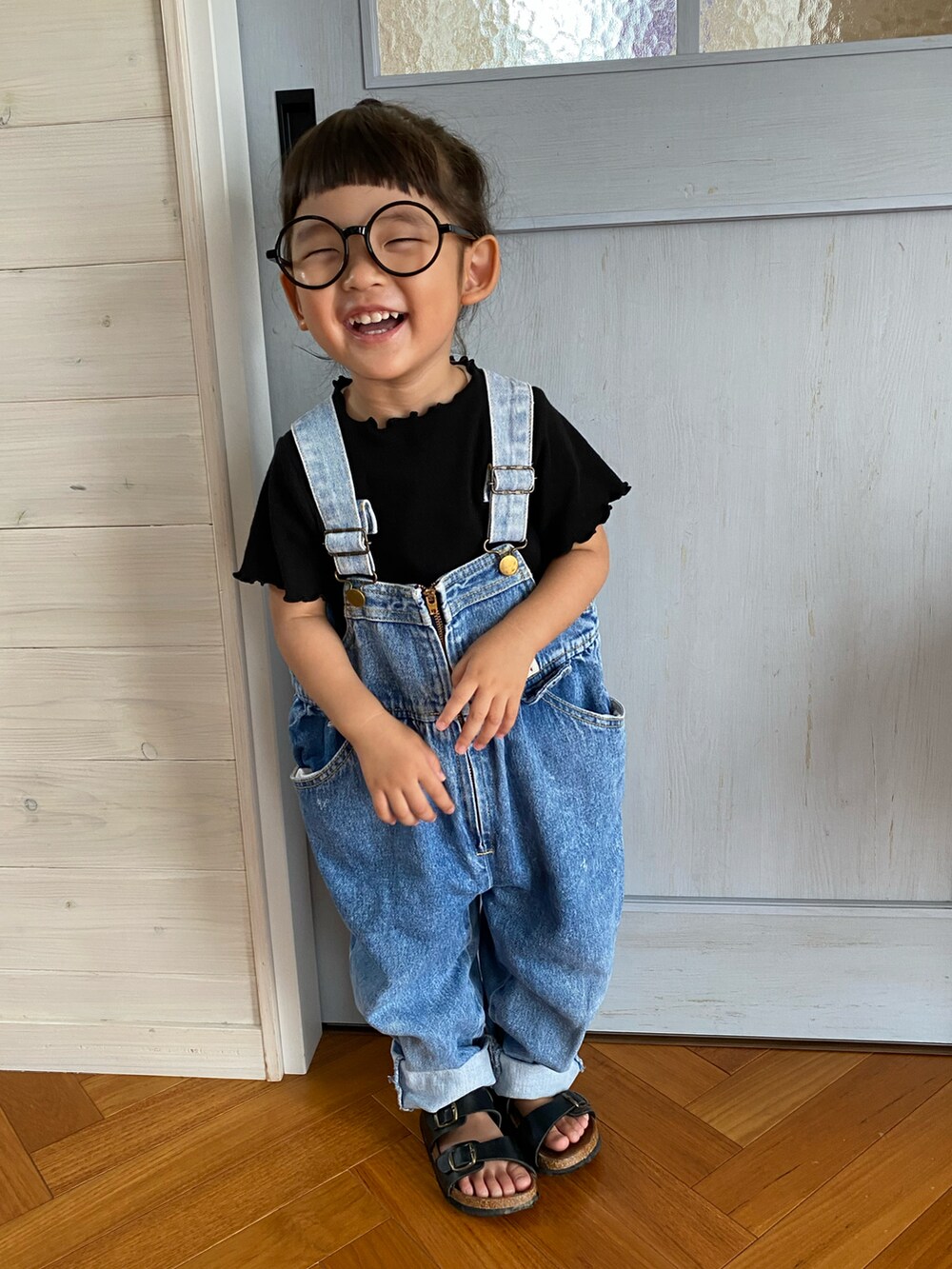 ブルー系のサロペット/オーバーオール、ブラック系のサンダル、ブラック系のTシャツ/カットソーを着用したキッズの夏コーディネートの2枚目の写真