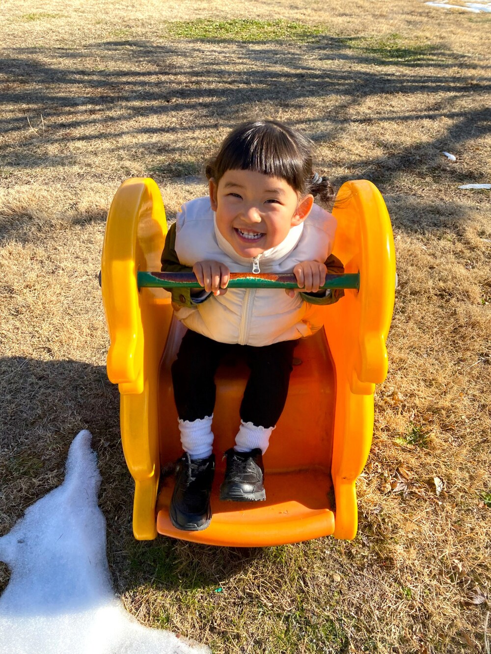 ホワイト系のダウンベスト、ブラック系のスニーカー、ブラック系のその他パンツを着用したキッズの冬コーディネートの3枚目の写真