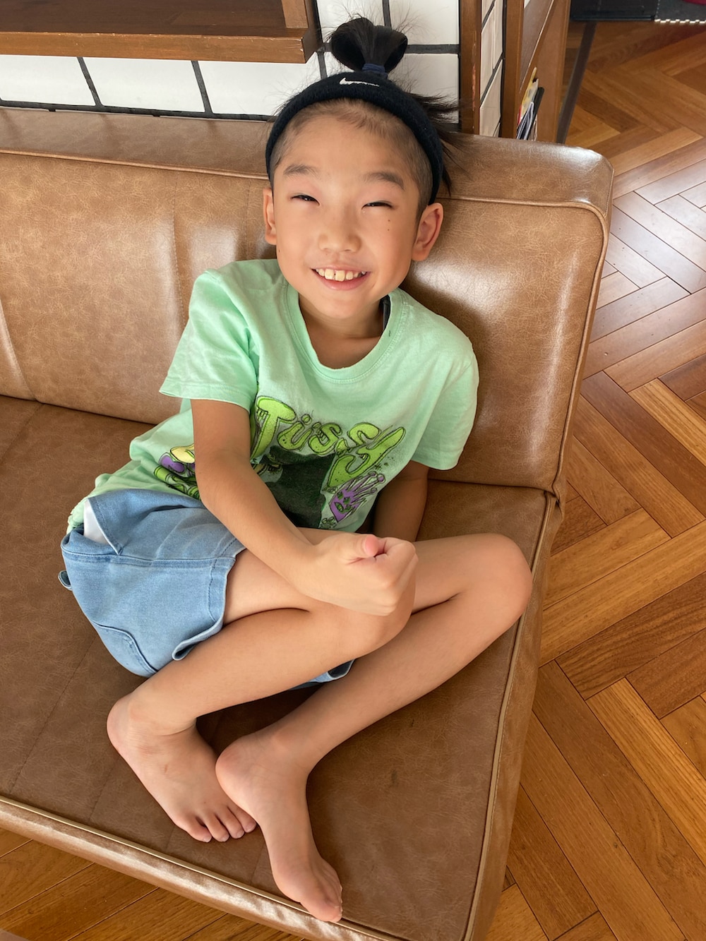 グリーン系のTシャツ/カットソー、ブルー系のデニムパンツ、ブラック系のヘアバンドを着用したキッズの秋コーディネートの2枚目の写真