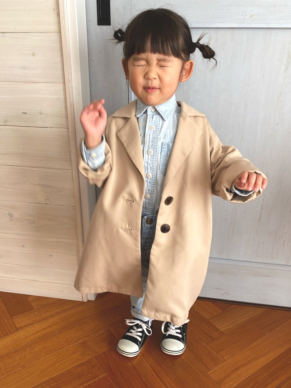 ベージュ系のチェスターコート、ブルー系のシャツ/ブラウス、ブラック系のスニーカーを着用したキッズの秋コーディネートの3枚目の写真