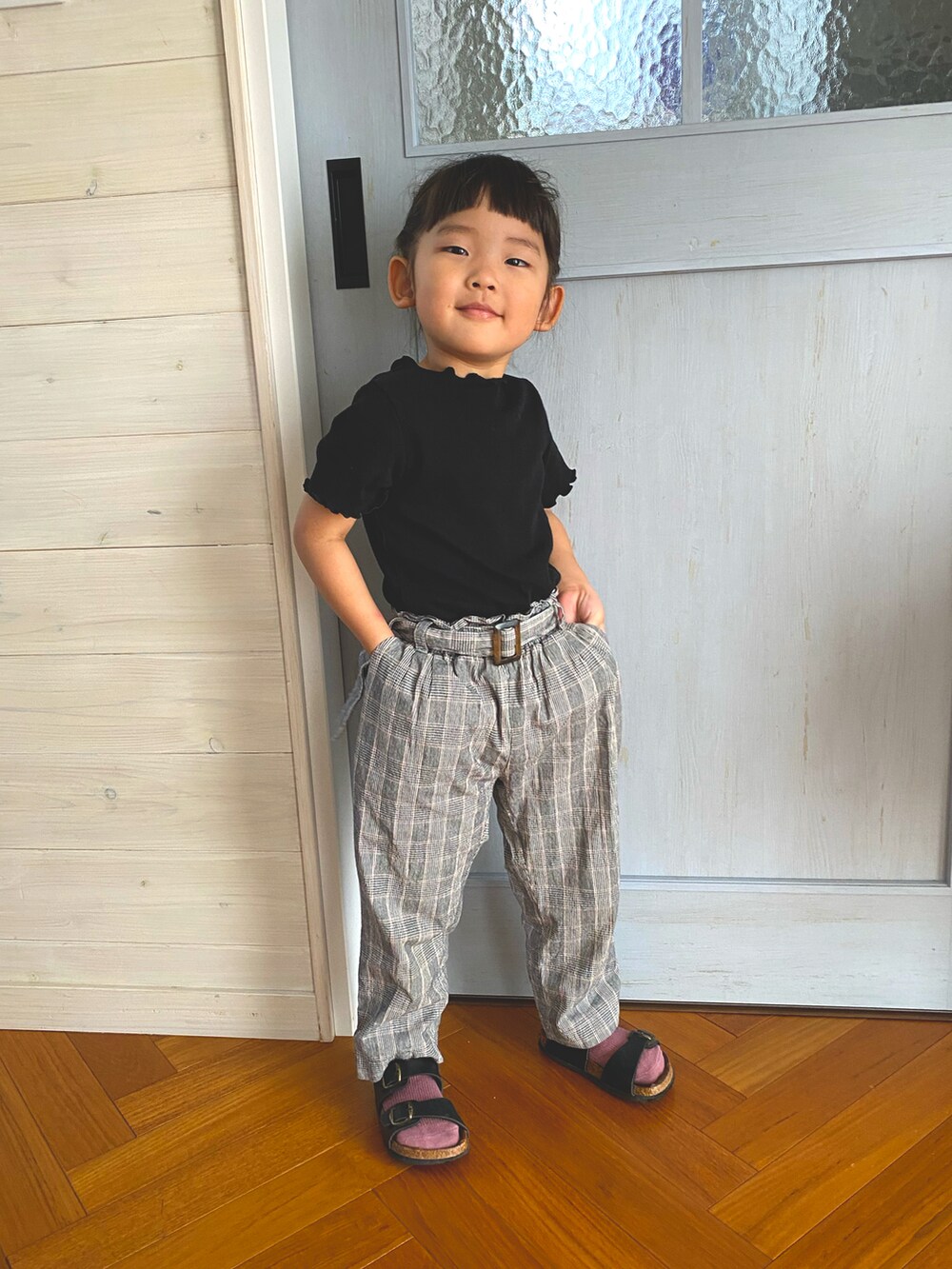 ブラック系のTシャツ/カットソー、グレー系のパンツ、ブラック系のサンダルを着用したキッズの秋コーディネートの2枚目の写真