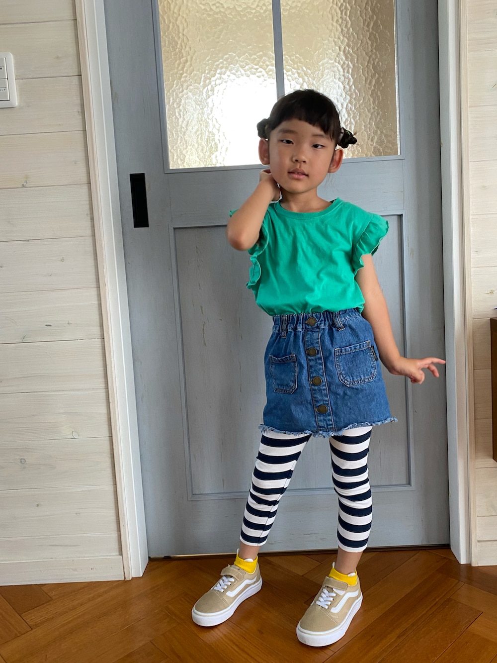 ブルー系のデニムスカート、グリーン系のTシャツ/カットソー、ホワイト系のパンツを着用したキッズの夏コーディネートの2枚目の写真