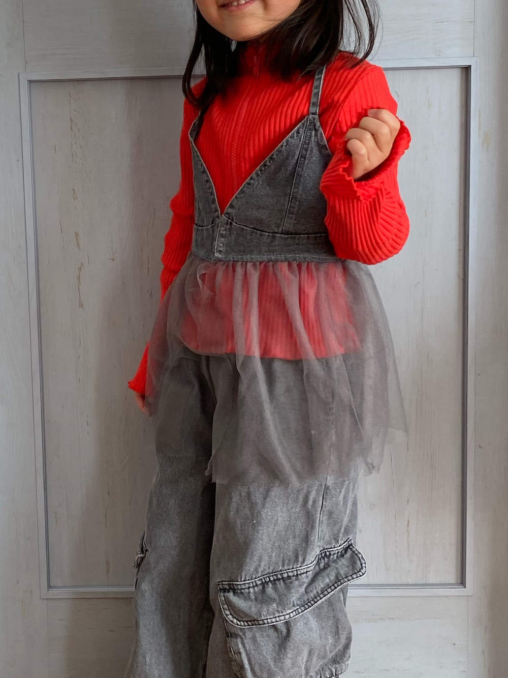 ブラック系のローファー、グレー系のデニムパンツ、グレー系のキャミソールを着用したキッズの冬コーディネートの2枚目の写真