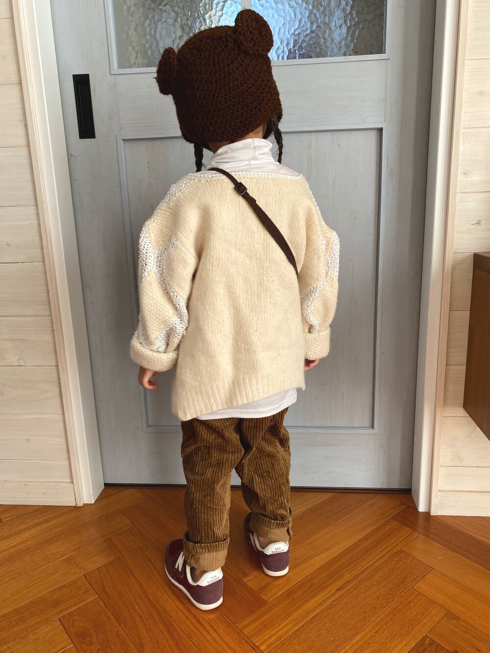 ベージュ系のハンドバッグ、ブラウン系のパンツ、レッド系のスニーカーを着用したキッズの冬コーディネートの2枚目の写真
