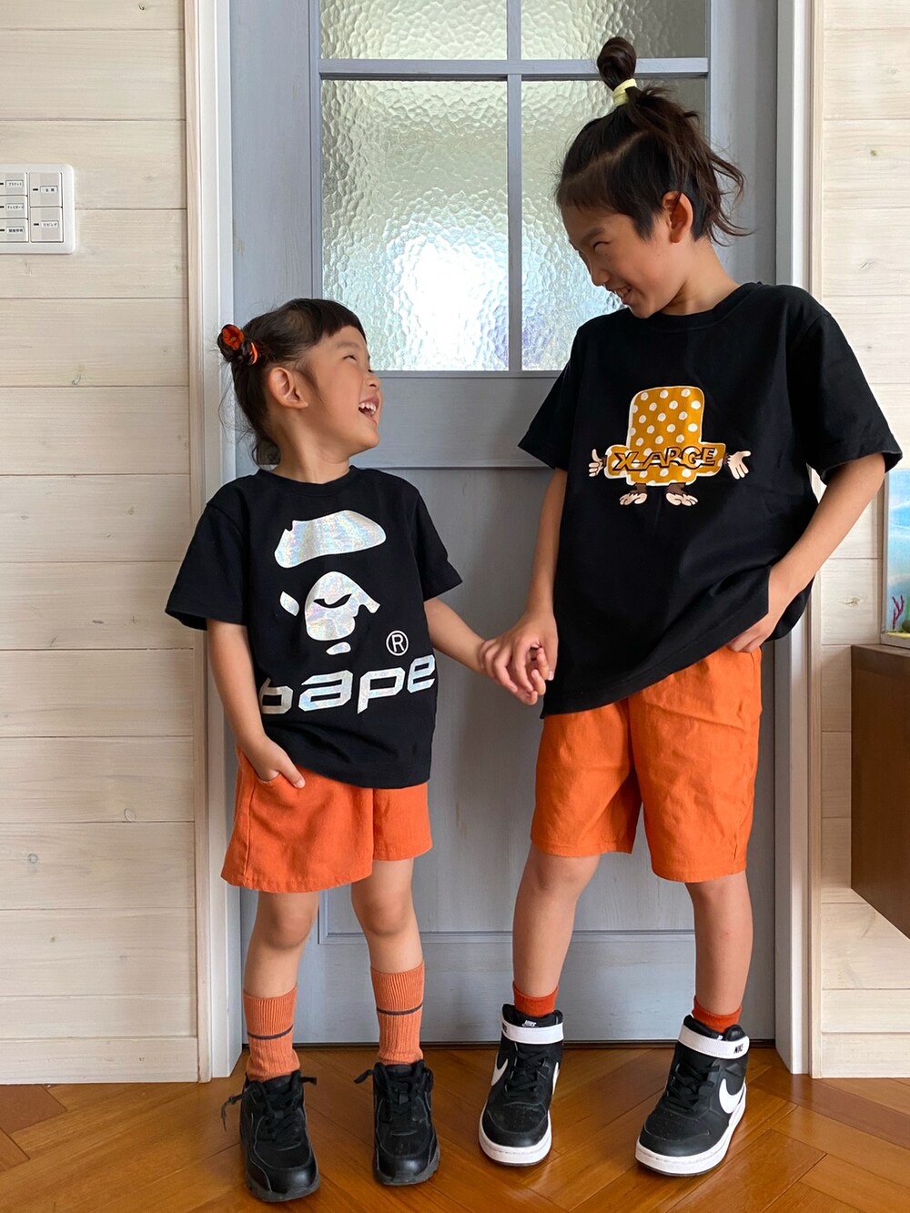 ブラック系のTシャツ/カットソー、オレンジ系のパンツ、ブラック系のTシャツ/カットソーを着用したキッズの夏コーディネートの2枚目の写真