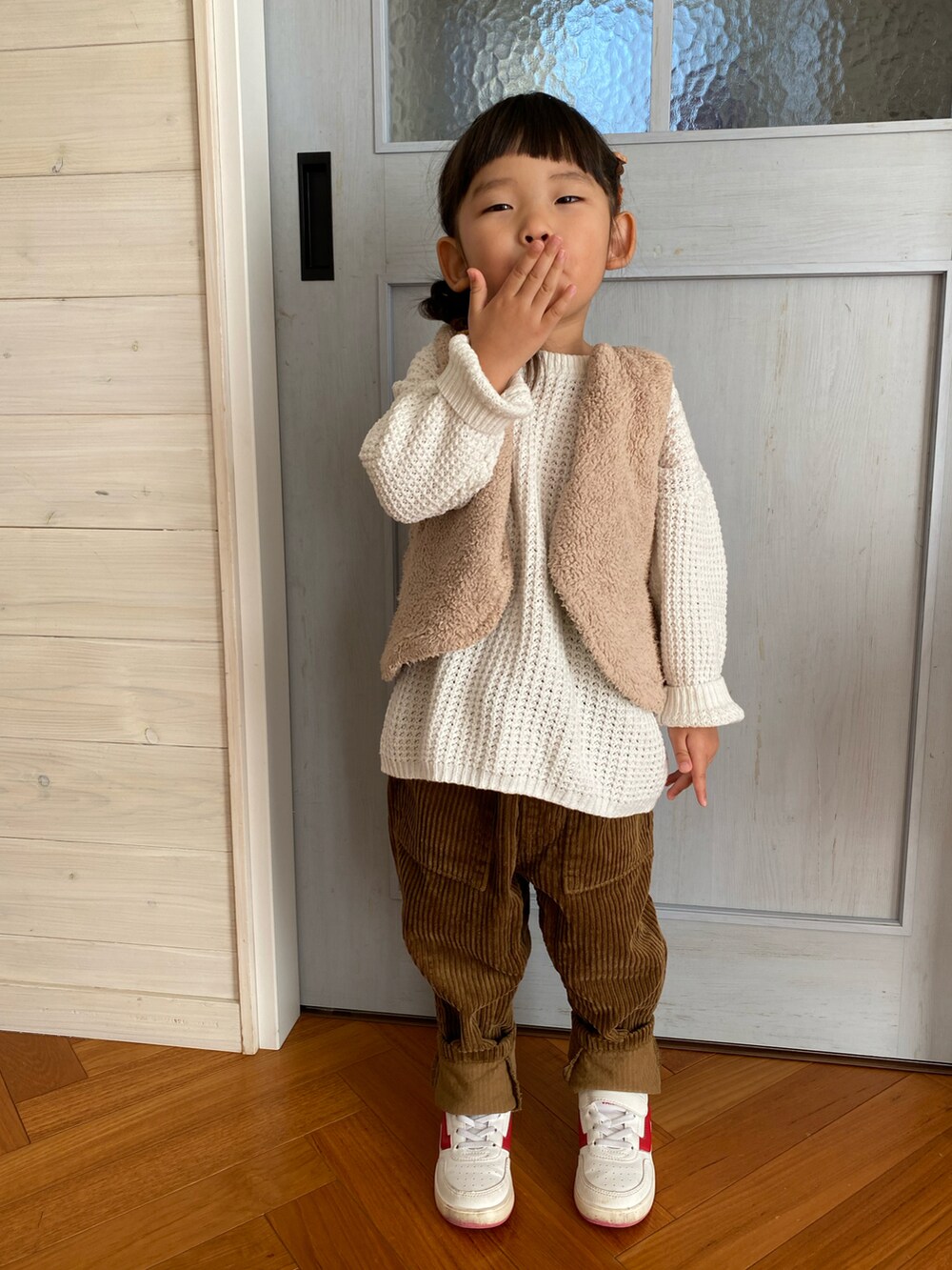 ブラウン系のパンツ、ホワイト系のスニーカーを着用したキッズの秋コーディネートの2枚目の写真