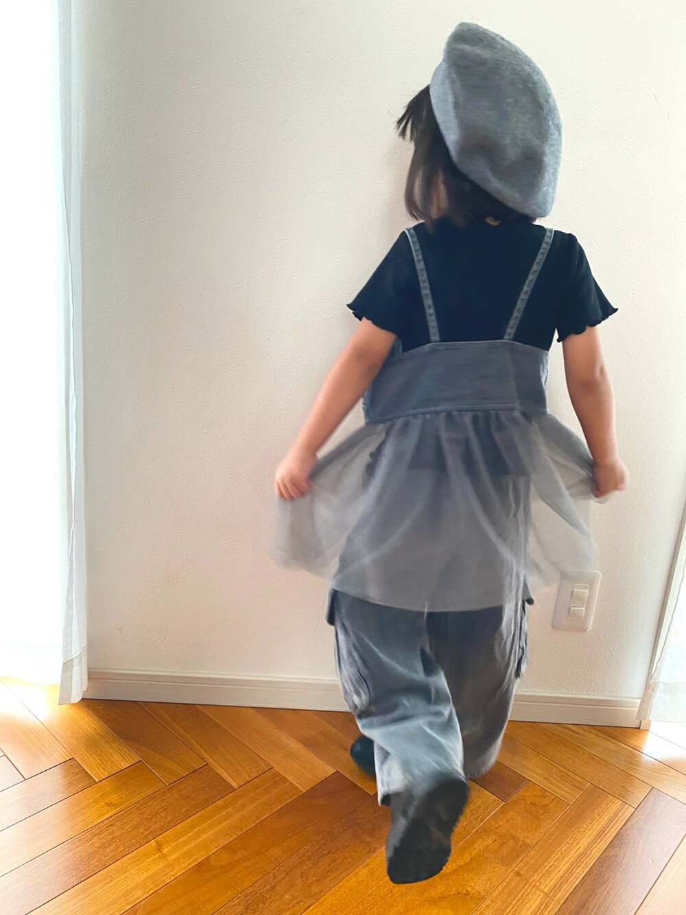 グレー系のキャミソール、グレー系のデニムパンツ、ブラック系のスニーカーを着用したキッズの秋コーディネートの3枚目の写真