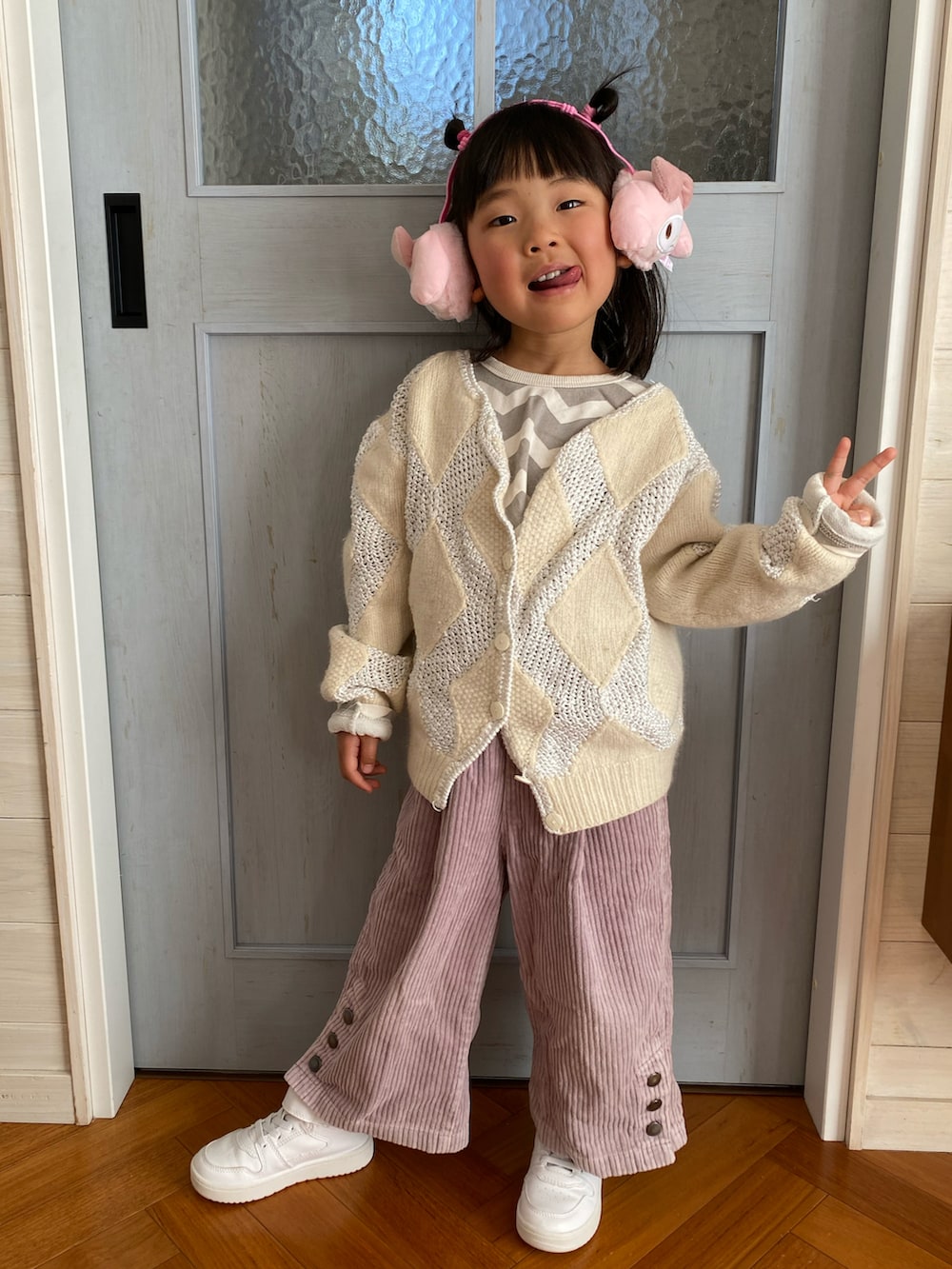 ピンク系のパンツ、グレー系のTシャツ/カットソー、ホワイト系のスニーカーを着用したキッズの冬コーディネートの3枚目の写真