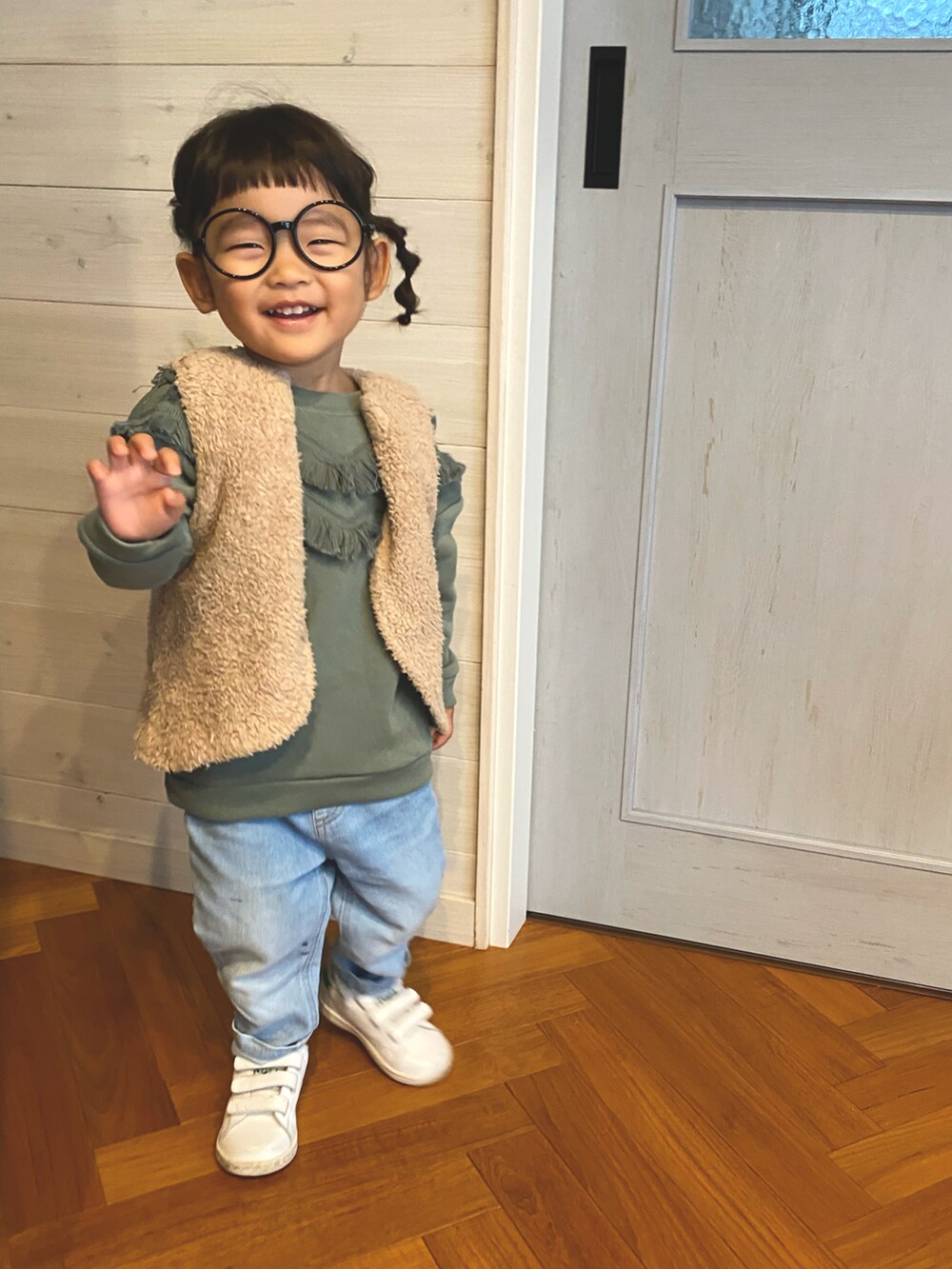 グリーン系のスウェット、ベージュ系のダウンベスト、ブラック系のメガネを着用したキッズの秋コーディネートの4枚目の写真