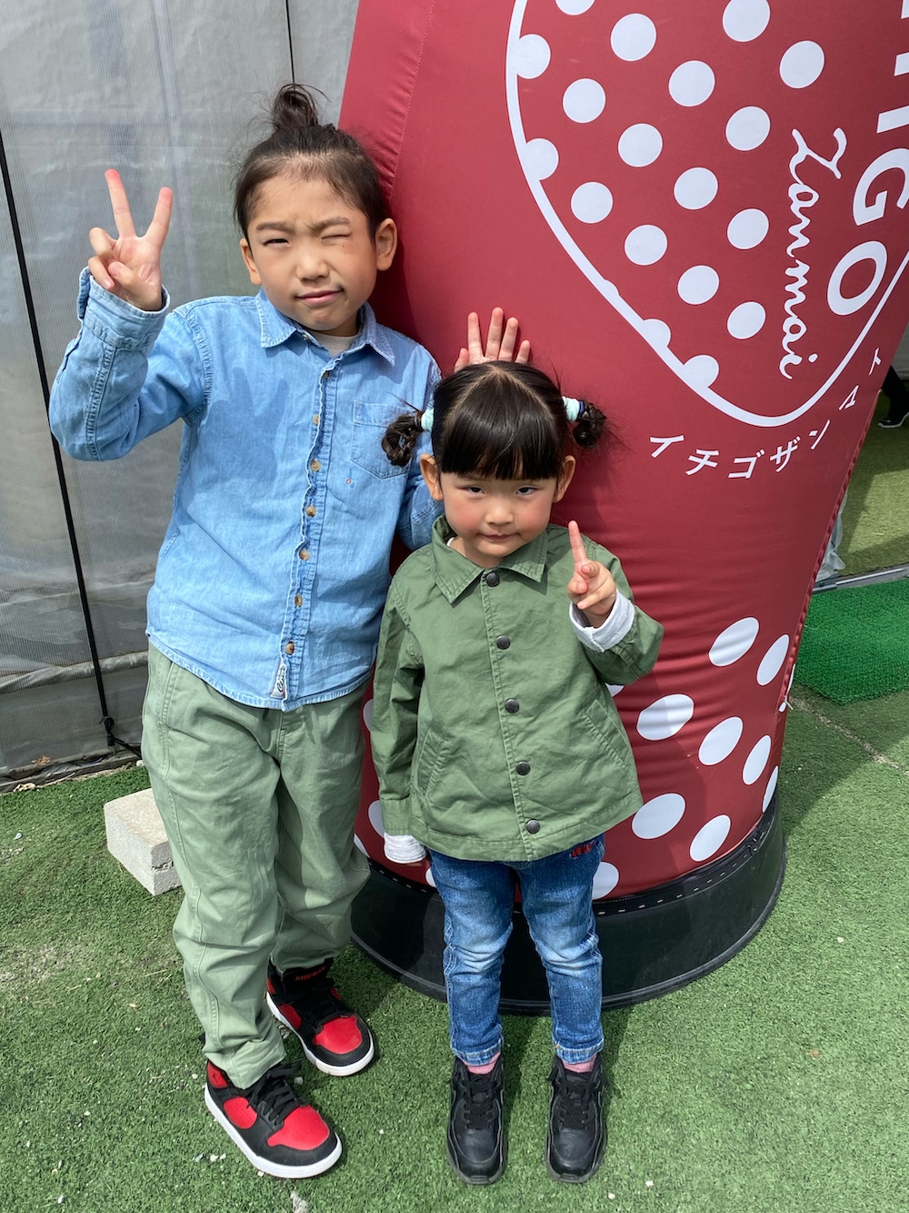 グリーン系のパンツ、ブルー系のシャツ/ブラウス、グリーン系のカバーオールを着用したキッズの春コーディネートの2枚目の写真