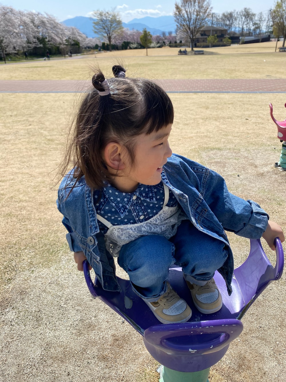 ブルー系のデニムジャケット、ブルー系のデニムパンツ、ホワイト系のアンサンブルを着用したキッズの春コーディネートの2枚目の写真