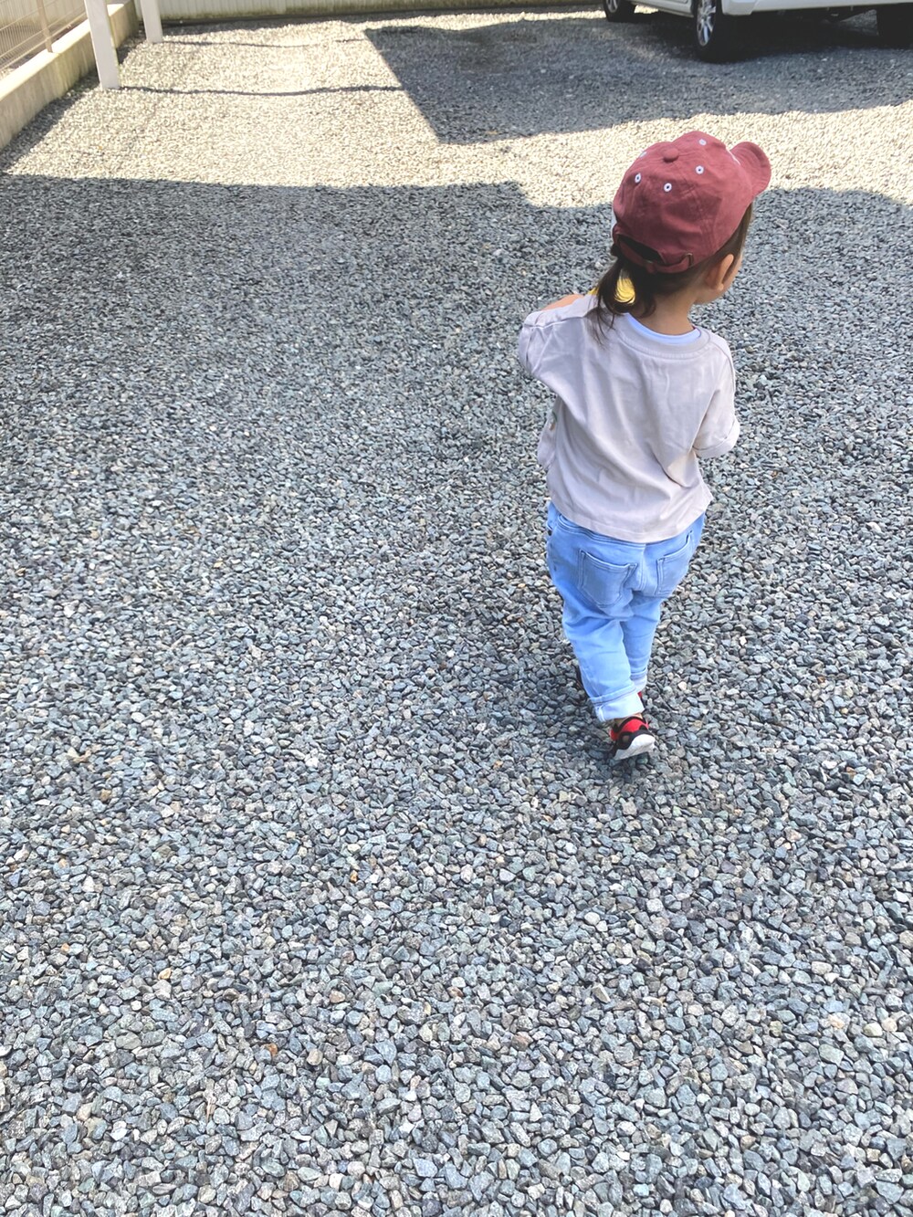 レッド系のサンダル、ベージュ系のTシャツ/カットソー、レッド系のキャップを着用したキッズの夏コーディネートの2枚目の写真