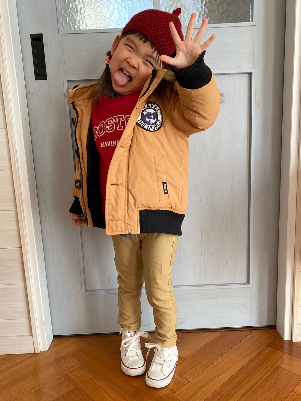 ベージュ系のその他アウター、レッド系のスウェット、ベージュ系のその他パンツを着用したキッズの冬コーディネートの2枚目の写真