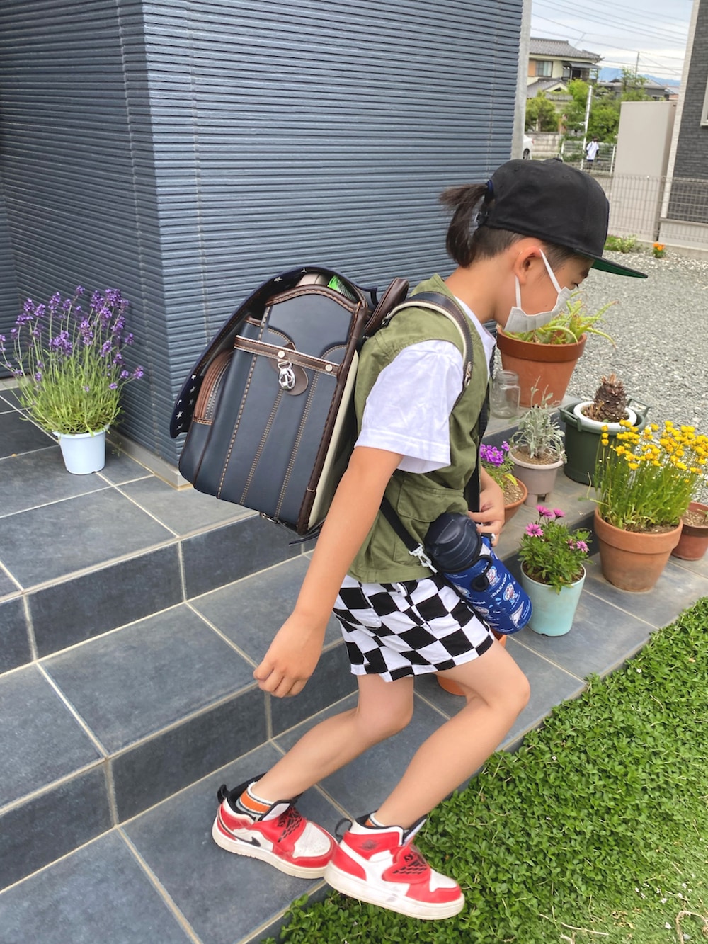 グリーン系のベスト、その他のその他パンツ、レッド系のスニーカーを着用したキッズの春コーディネートの2枚目の写真